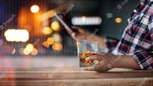 Homem bebendo whisky e relaxando.